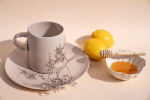 Una taza acompañada con miel y limón